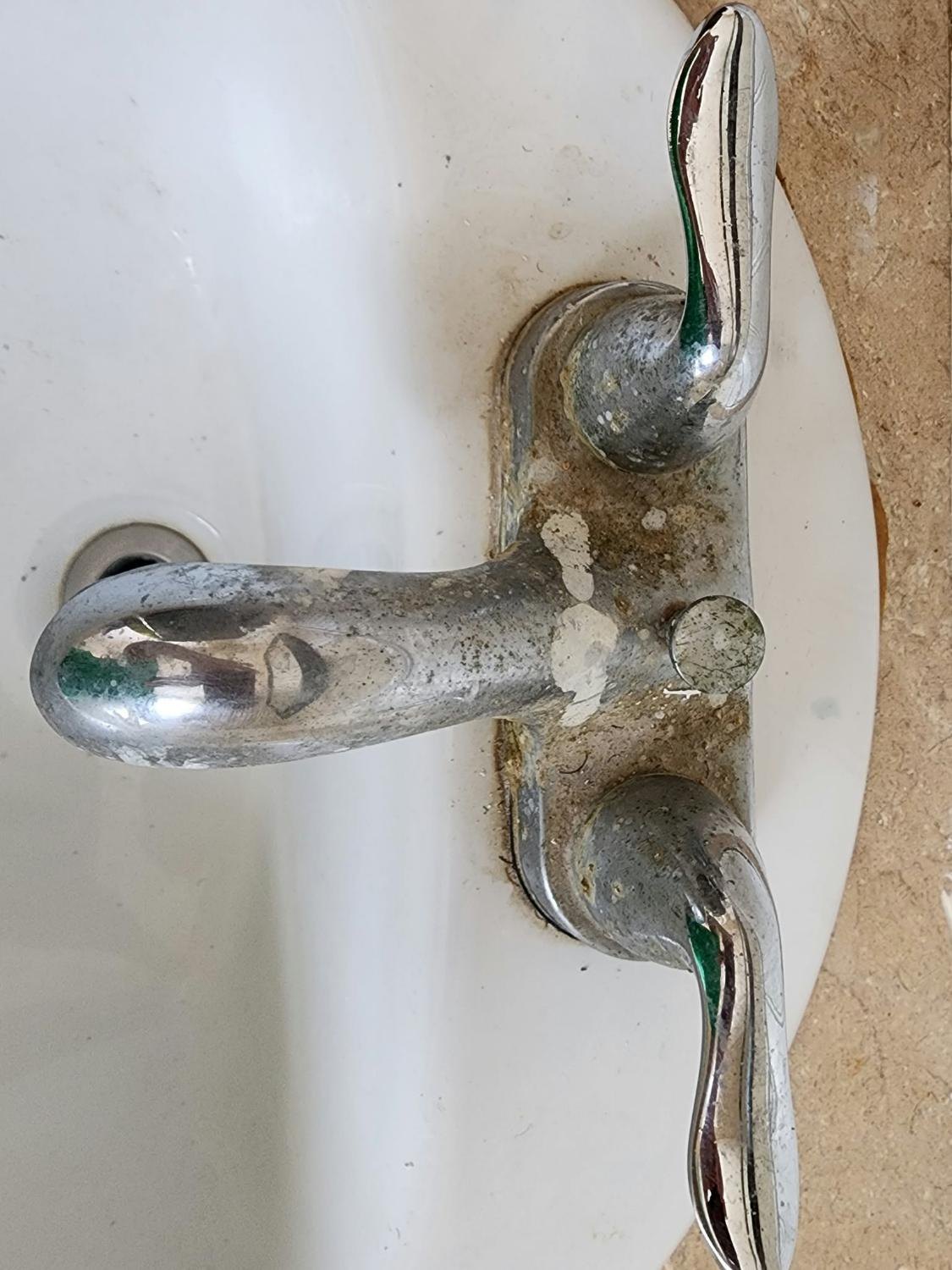 Bathroom faucet covered in hard-water scale