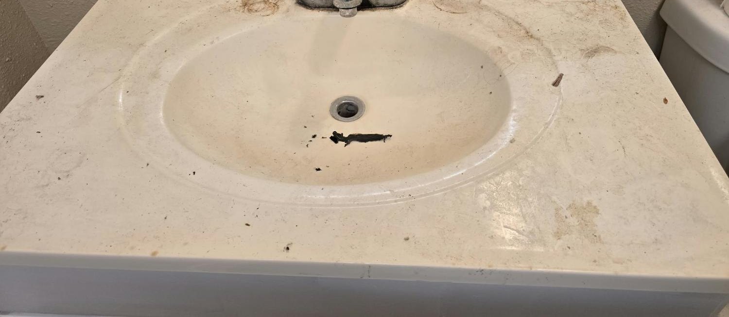 Bathroom sink and counter covered in grime